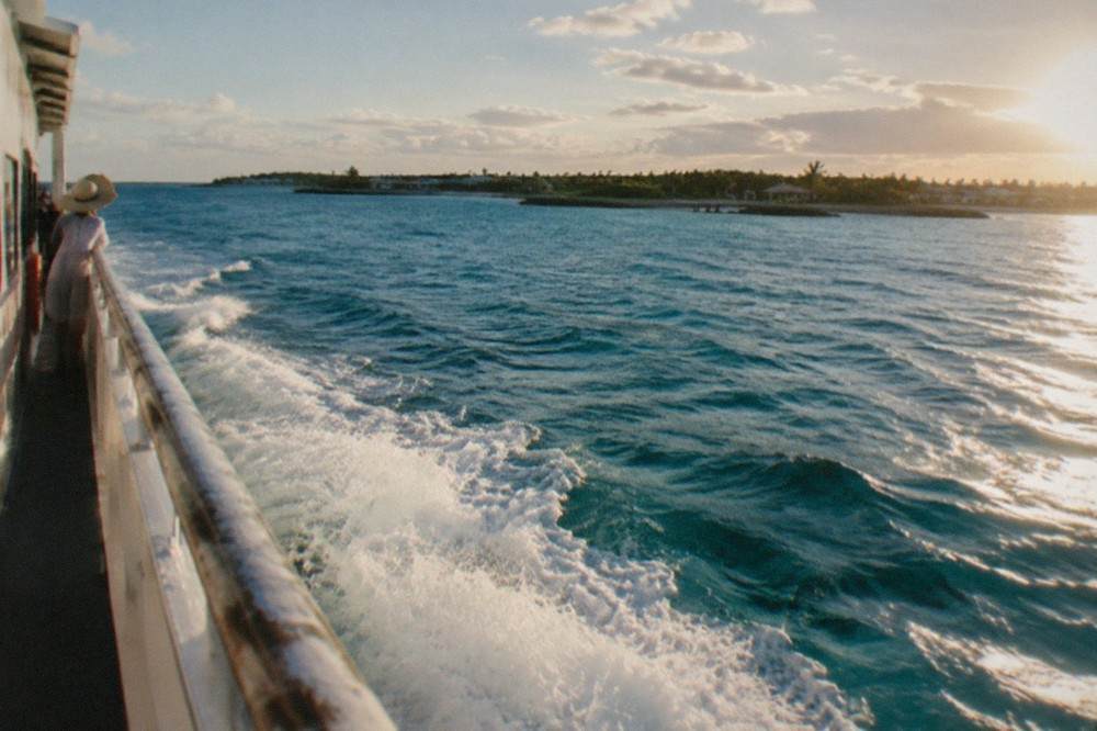 Passenger ferry cruising on open turquoise sea toward a small island