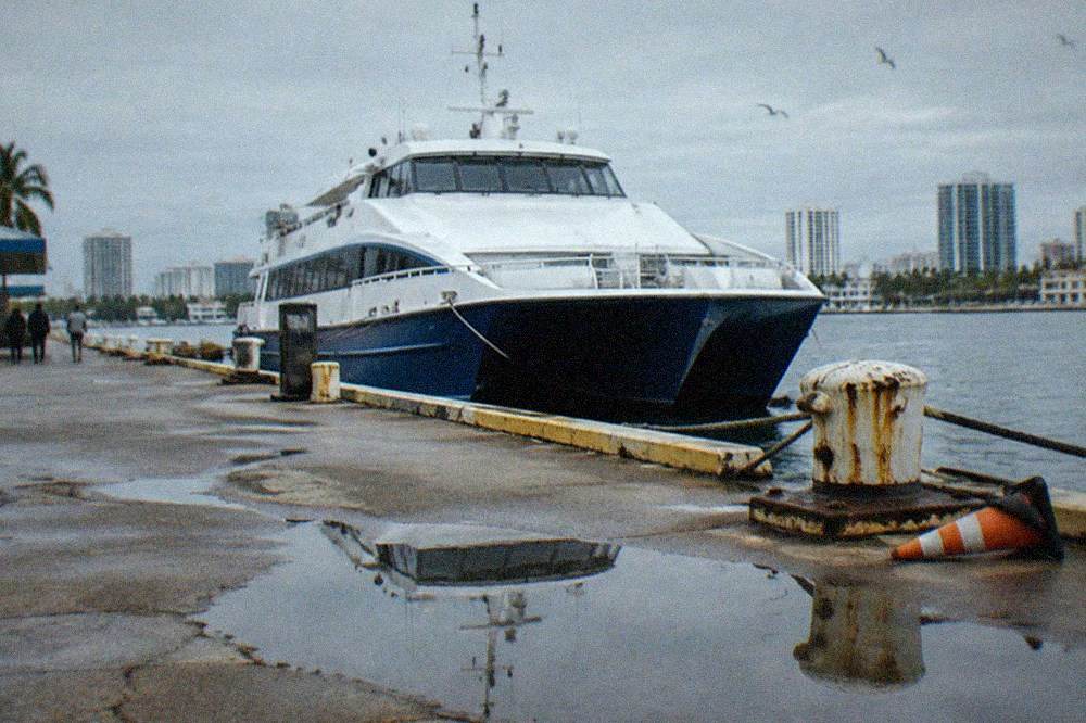 Ferry terminal dock with a moored high speed vessel on calm water