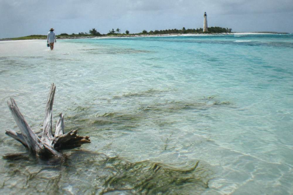 Turquoise shallows and a sandbar near a small Bahamian island shoreline