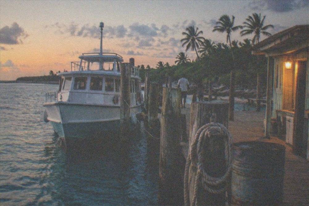 Ferry terminal dock at dusk with a passenger vessel moored beside the pier