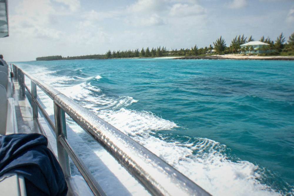 Passenger ferry cruising on open water toward an island shoreline