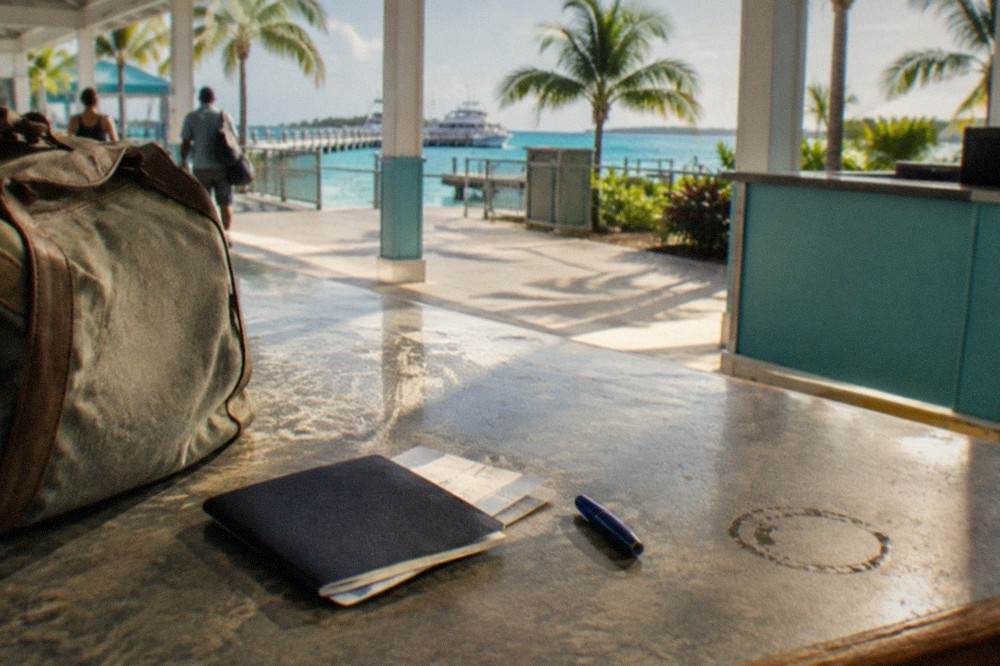 Passport book and ferry ticket resting on a counter beside a travel bag
