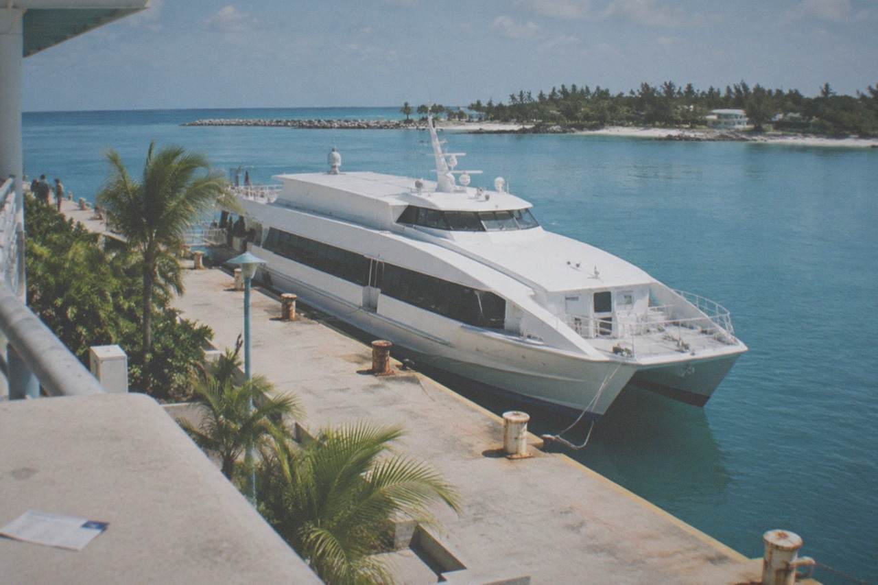 High-speed ferry docked at a port terminal on a calm sunny morning