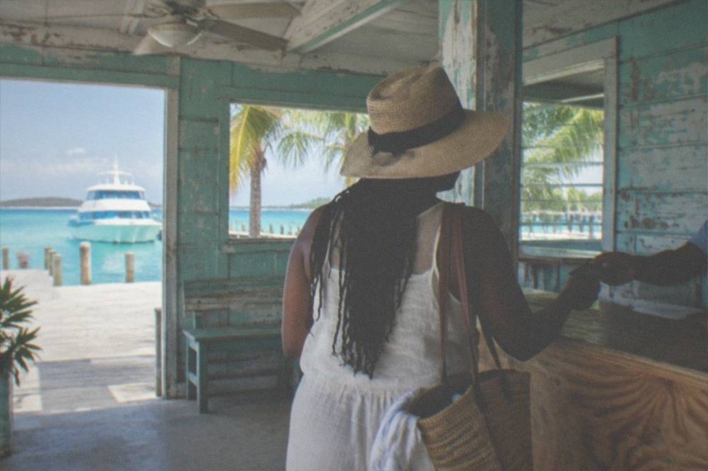 Traveler handing a passport to an officer at a small ferry terminal counter