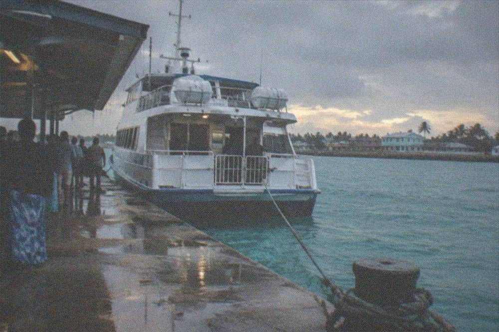 Ferry vessel docked at a terminal with passengers waiting to board
