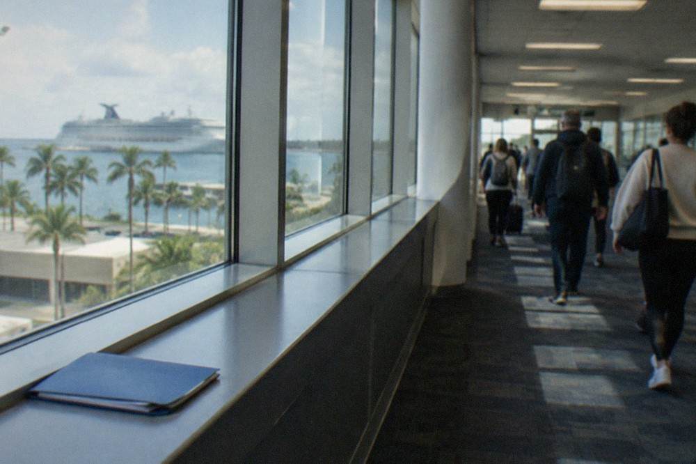 Ferry passengers walking through a terminal corridor with backpacks and day bags