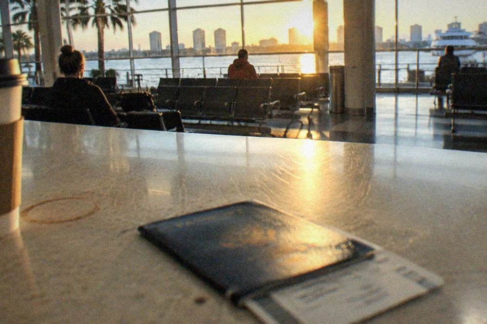 Open passport book resting on a boarding pass at a ferry check-in counter