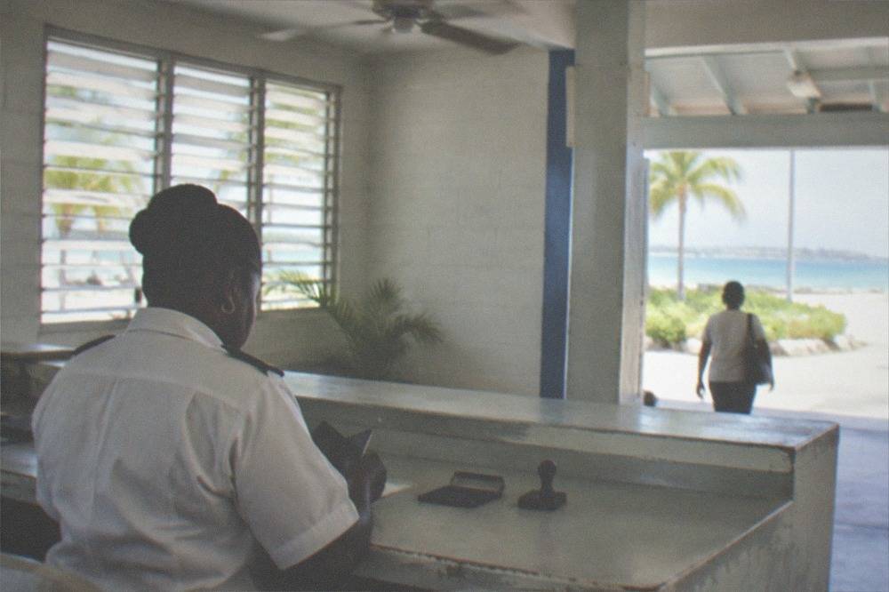 Customs desk with an officer's counter and signage inside a small ferry terminal building