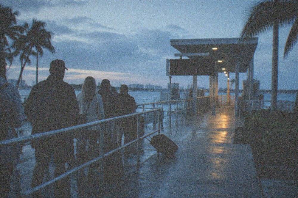 Ferry terminal departure board and boarding queue in early morning light