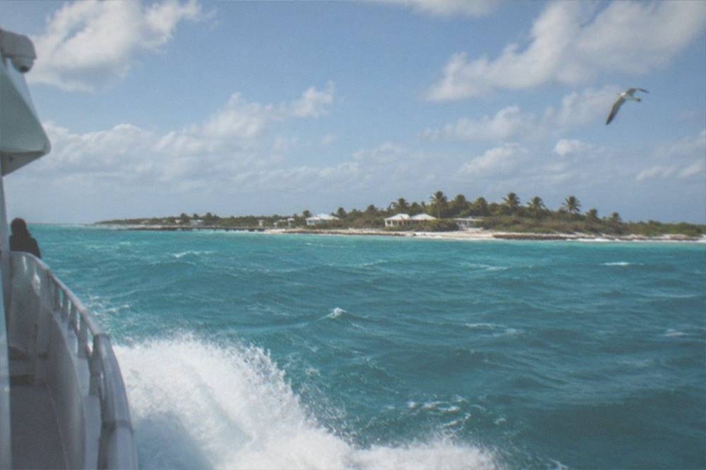High-speed ferry cutting through open water with spray at the bow