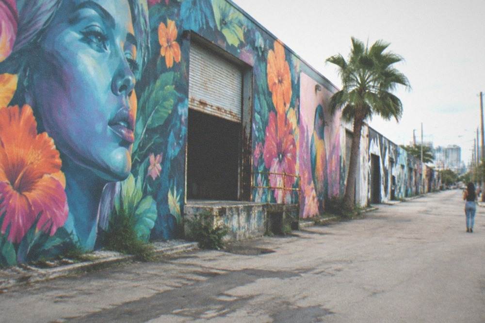 Building walls covered in large colorful murals along a city street