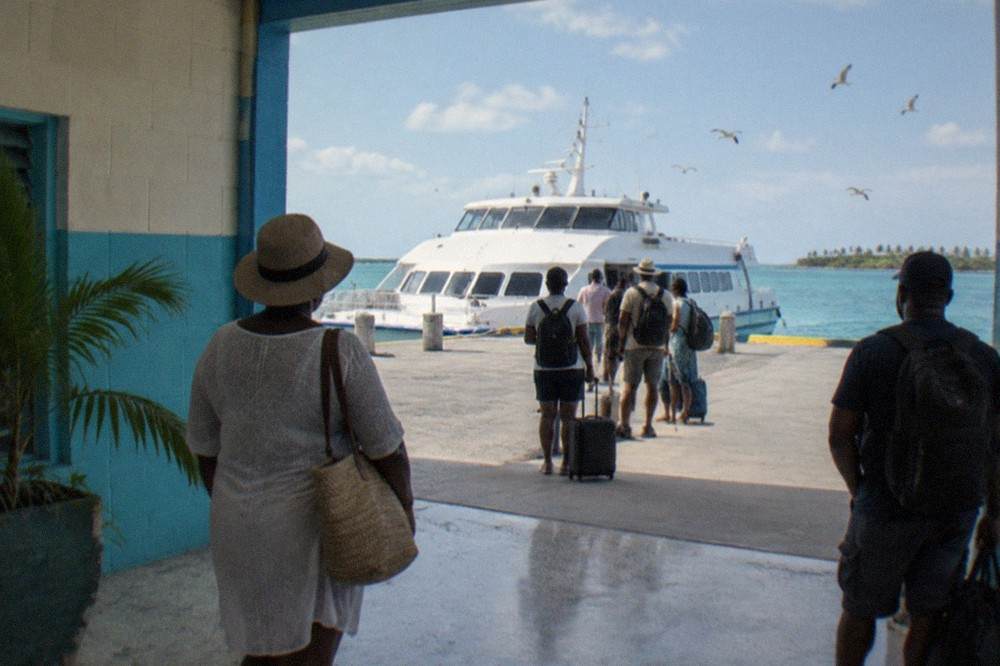 Passenger ferry docked at a port terminal with travelers waiting to board