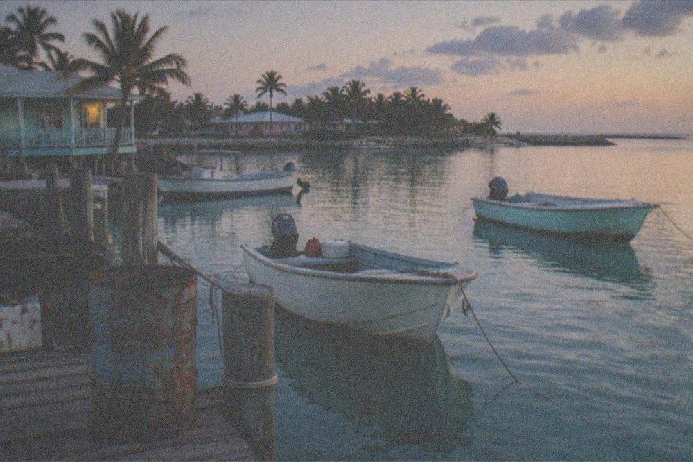 Small boats anchored near a wooden dock in calm island water