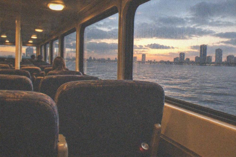 Ferry cabin interior with rows of seated passengers during an evening crossing