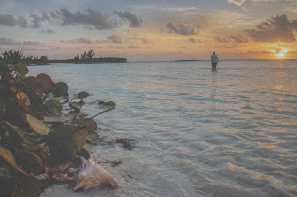 Clear shallow water over a sandbar near a small Bahamian island shoreline