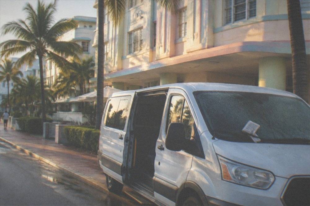 Shuttle van waiting outside a Miami Beach hotel entrance in early morning light
