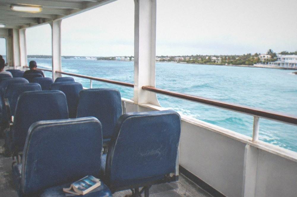 Open-air seating area on a ferry deck with rows of seats facing windows