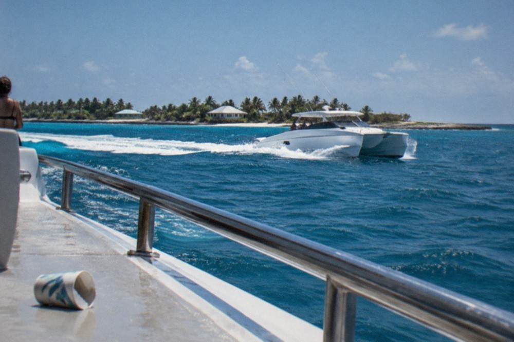 A high-speed catamaran ferry crossing open blue water under a clear sky